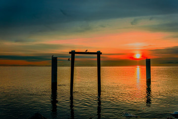 Sunset of the winter sun over the ocean, reflection in the water,