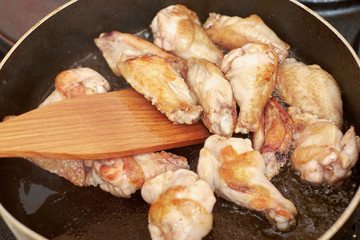 chicken wings frying with oil on a hot pan