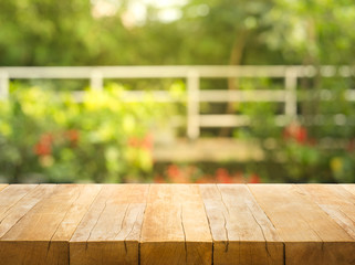 Empty wood table top on blur abstract garden and house background