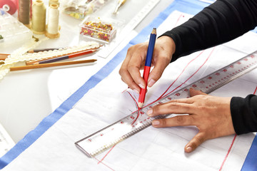Dressmaker designer making pattern and measure garment, Asian fashion designer working in her showroom studio.