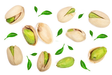 Pistachios decorated with leaves isolated on white background, top view. Flat lay pattern