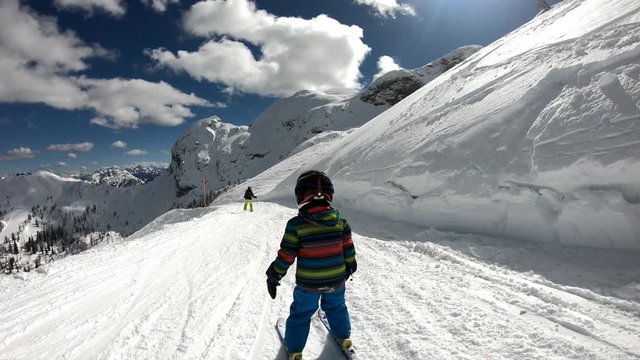 Little boy skiing in the Alpine resort.
A 5 year old child enjoys a winter holiday with his mother. Stabilized footage. Slow motion.
