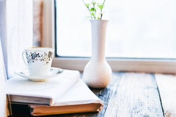 open book, coffee mug by the window, the concept of dreams and thoughtfulness
