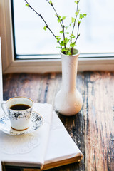 open book, coffee mug by the window, the concept of dreams and thoughtfulness