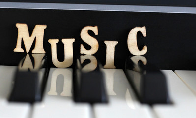 Piano keys closeup with the letters music
