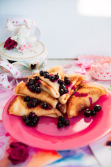 Breakfast: pancakes with blueberry berries, currants on a pink plate in the style of Provence.. dessert