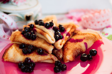 Breakfast: pancakes with blueberry berries, currants on a pink plate in the style of Provence.. dessert