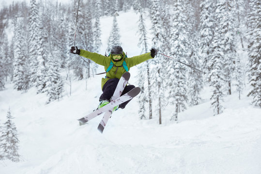 Skier jumps offpiste ski slope resort