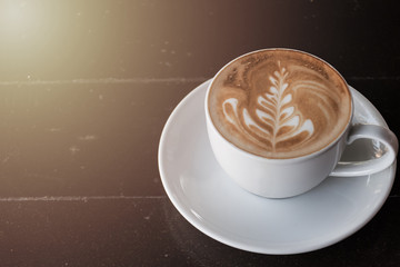 A cup of coffee in a white cup on wooden background
