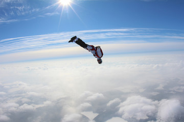 Skydiver is flying in the winter sky.
