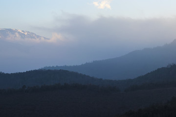 Fototapeta premium Foggy mountain crest landscape on a blue sky sunset