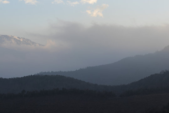 Foggy mountain crest landscape on a blue sky sunset