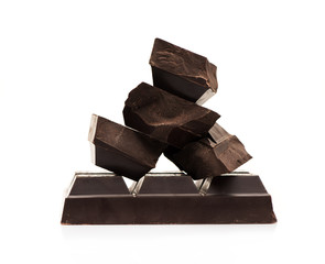 Block and pieces of chocolate on a white background