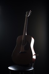 Acoustic guitar in the studio on a chair