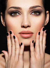 Face of a beautiful girl with fashion makeup and black nails