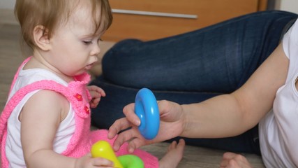 Mom plays with child in multi-colored toys, closeup