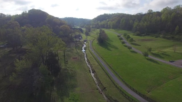 Flying Over Farms Through Lush Green Hills