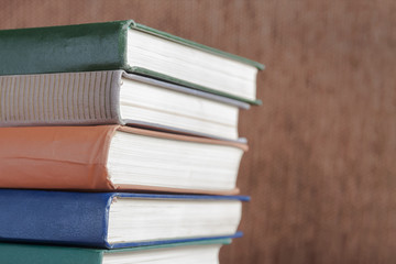 Pile of old books on brown background. Closeup, selective focus.