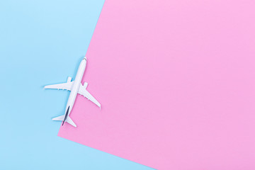 White blank model of passenger airplane on pastel colored paper texture