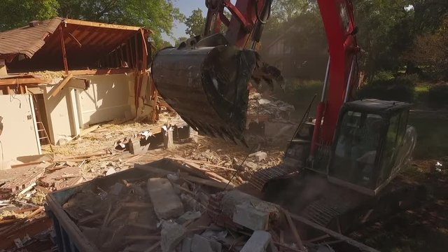 Excavator Dropping Debris in Dumpster