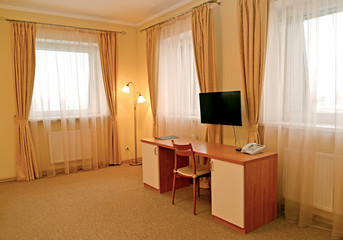 Fragment of an interior of the hotel room with a desk and a floor lamp. Modern classics
