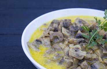Cooked mushrooms in a white mask on a black wooden background