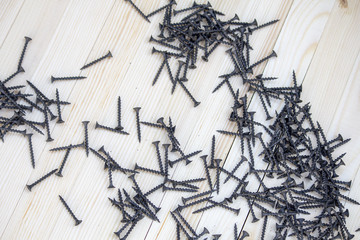 Screws on wooden planks. Wood screws pile on aged wooden surface.