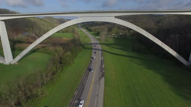 Following Highway And Over Bridge Through Lush Green Hills