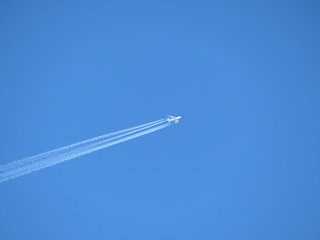 Trail of jet plane on clear blue sky. Airplane in the sky with contrail