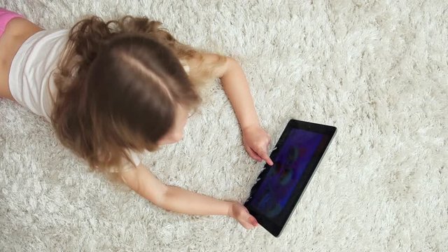 Modern child using digital tablet, playing computer game. Leisure activity and childhood. 