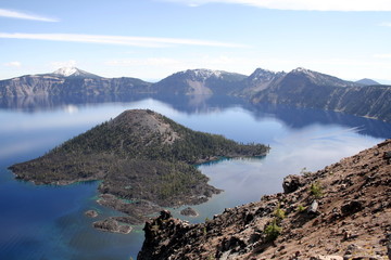 A view of Wizard Island in the blue water of the lake in the Crater Lake National Park in a sunny day, Oregon, USA