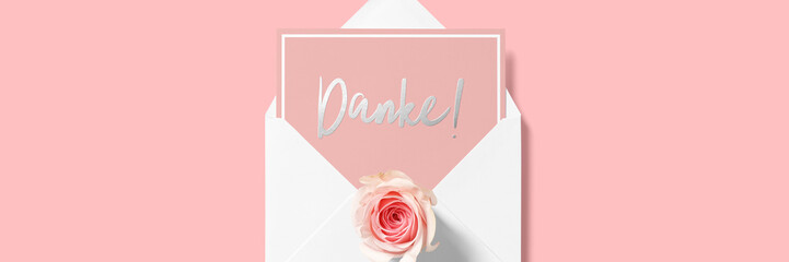 Danke - Kalligraphie auf einer Karte mit Rosenblüte