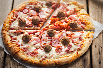Meat feast pizza with ham, bacon, beef