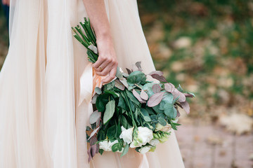 Beautiful bride with a wedding bouquet in their hands outdoors in a park © nazariykarkhut