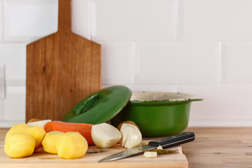 fresh peeled vegetables, potatoes, carrots and onions on the cutting Board