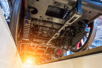 View of the locomotive from underneath the wheels on the between the rails, view from the repair pit.