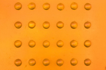 Rivets on metal with a touch of warm color background.