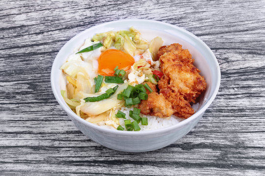 Jasmine rice with deep fried Chicken topped  soft boil eggs and fried pork with mixed vegetablein Japanese style.