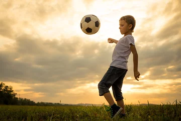 Foto op Plexiglas Young little boy playing in the field  with soccer ball. © altanaka