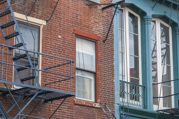 Matching color buildings/Street windows on two neighboring buildings painted in blue and red bricks.