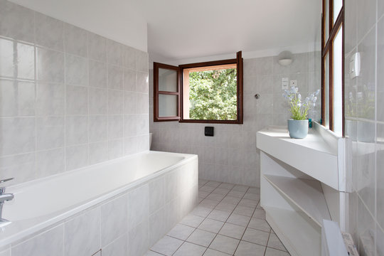 white large clean bathroom in home with window