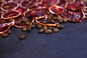 Dried red orange slices with a coffee beans on a stone background. Beautiful and tasty background for design.