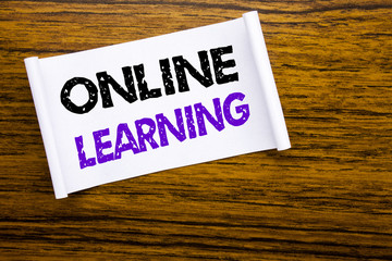 Word, writing Online Learning. Business concept for E-learning Training written on sticky note paper on the wooden wood structure visible background.