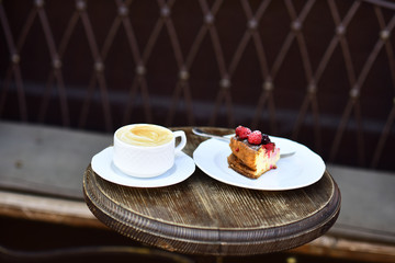 A composition with a cup of coffee and cheesecake