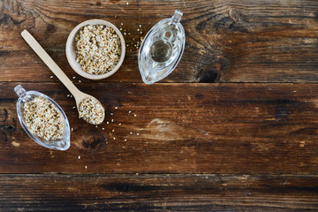 sesame seed oil and sesame seed oil in glass Cup on natural wooden background, healthy food concept, organic food.