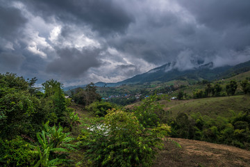 Village in the hill of forest mountain with cloudy sky behind, Traveling in Thailand