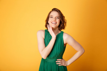 Obraz premium portrait of young smiling woman akimbo isolated on orange
