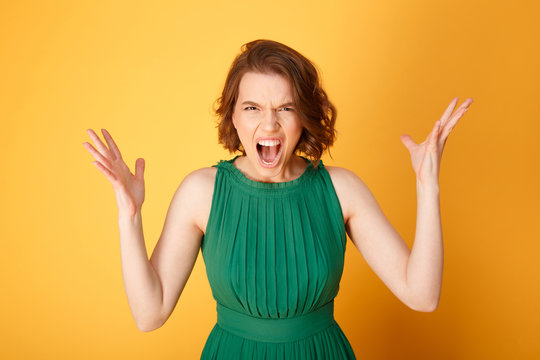 portrait of screaming angry woman isolated on orange