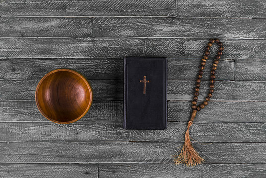 ancient bible and rosary on an old wood table