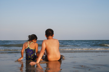 Fototapeta premium Happy children sitting on Hua Hin beach in sunny day.